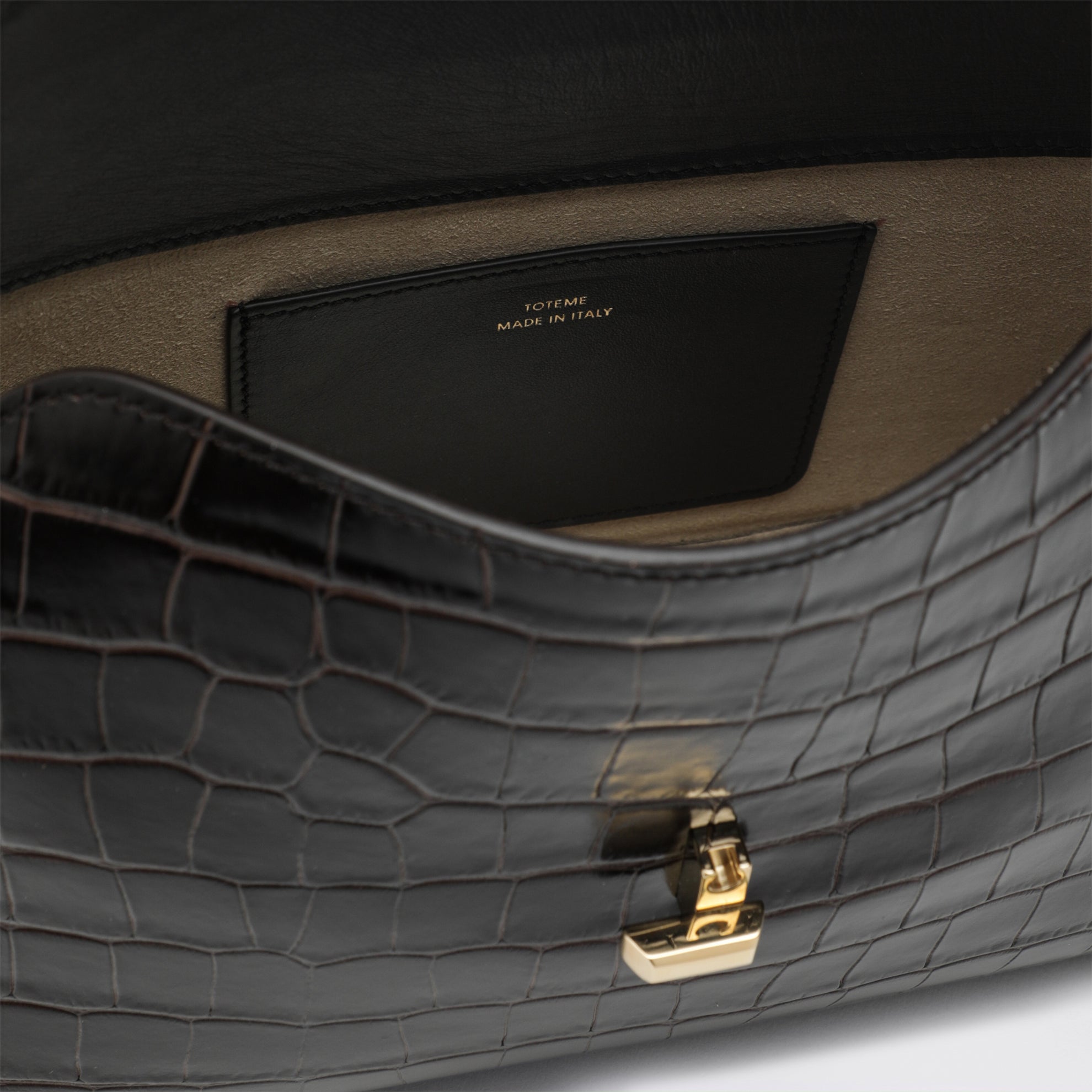 Brown T-lock clutch in crocodile-embossed leather