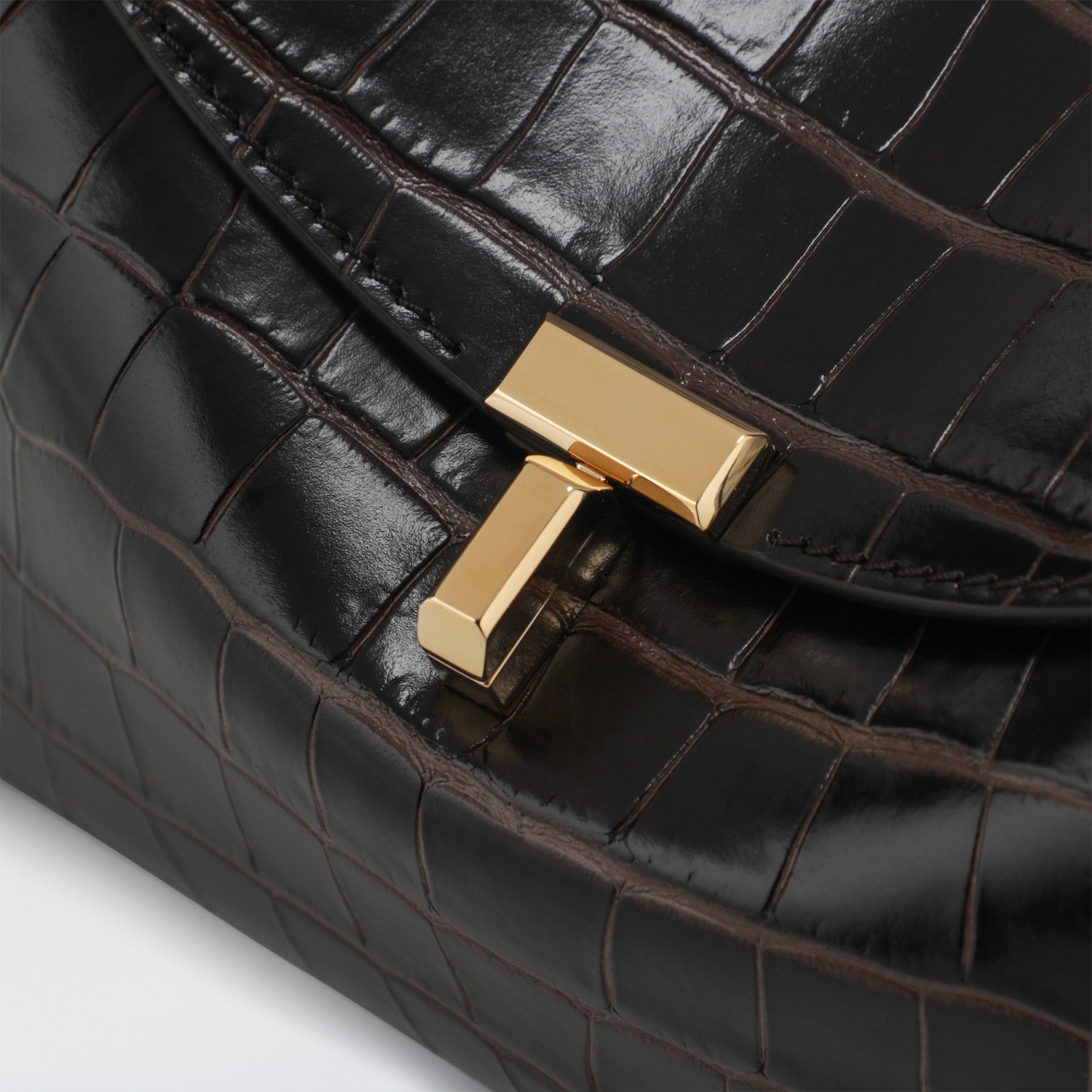 Brown T-lock clutch in crocodile-embossed leather