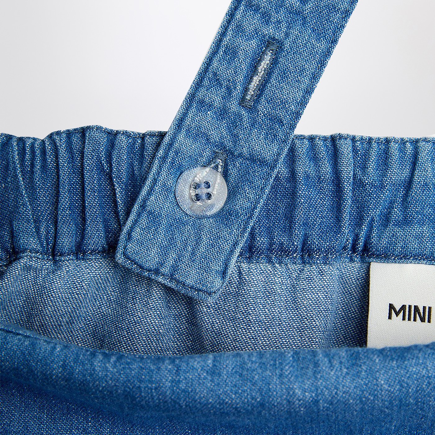 Salopette azzurra in denim con note musicali