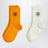 Deux paires de chaussettes blanc/orange avec broderie ballon de football