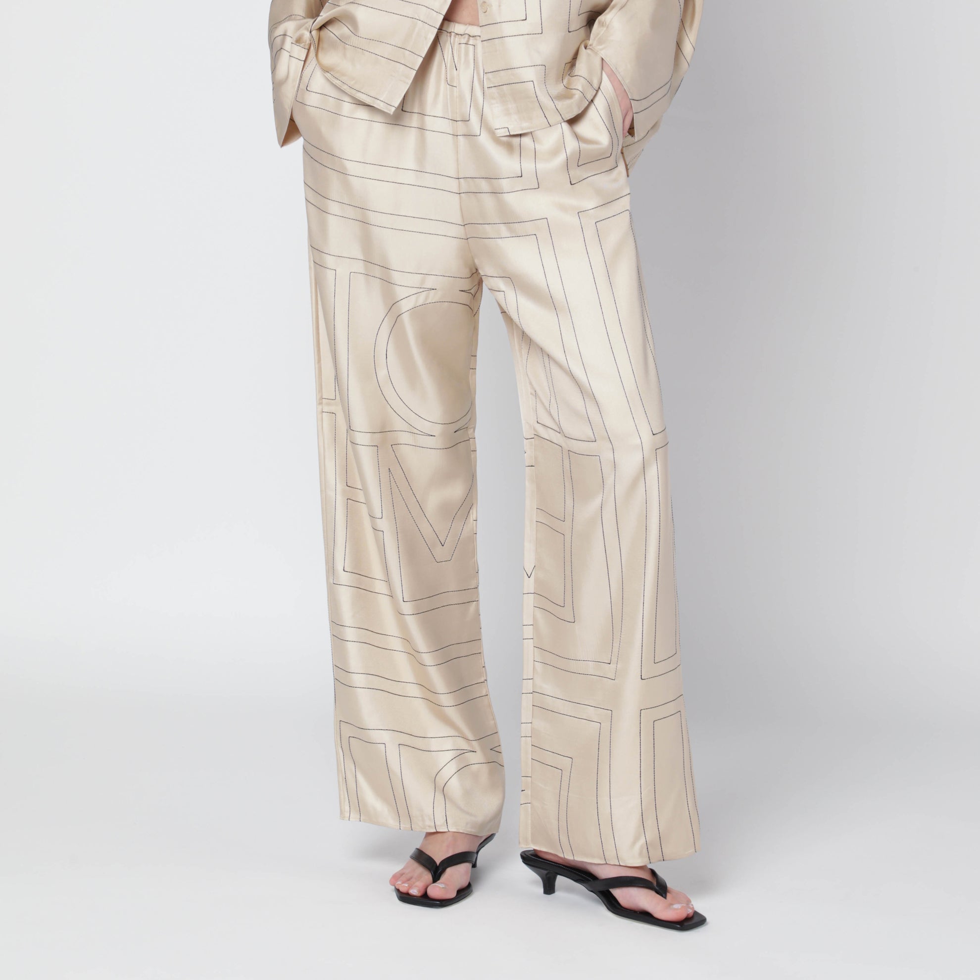 Elfenbeinfarbene Seidenhose mit Monogramm