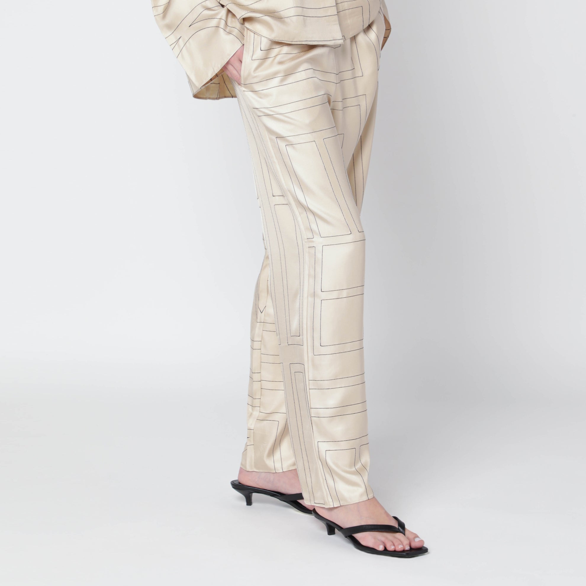 Elfenbeinfarbene Seidenhose mit Monogramm