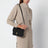 Pochette en cuir noir avec fermeture à cadenas en T