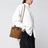 Borsa a mano Andiamo piccola in suede intrecciato color ambra