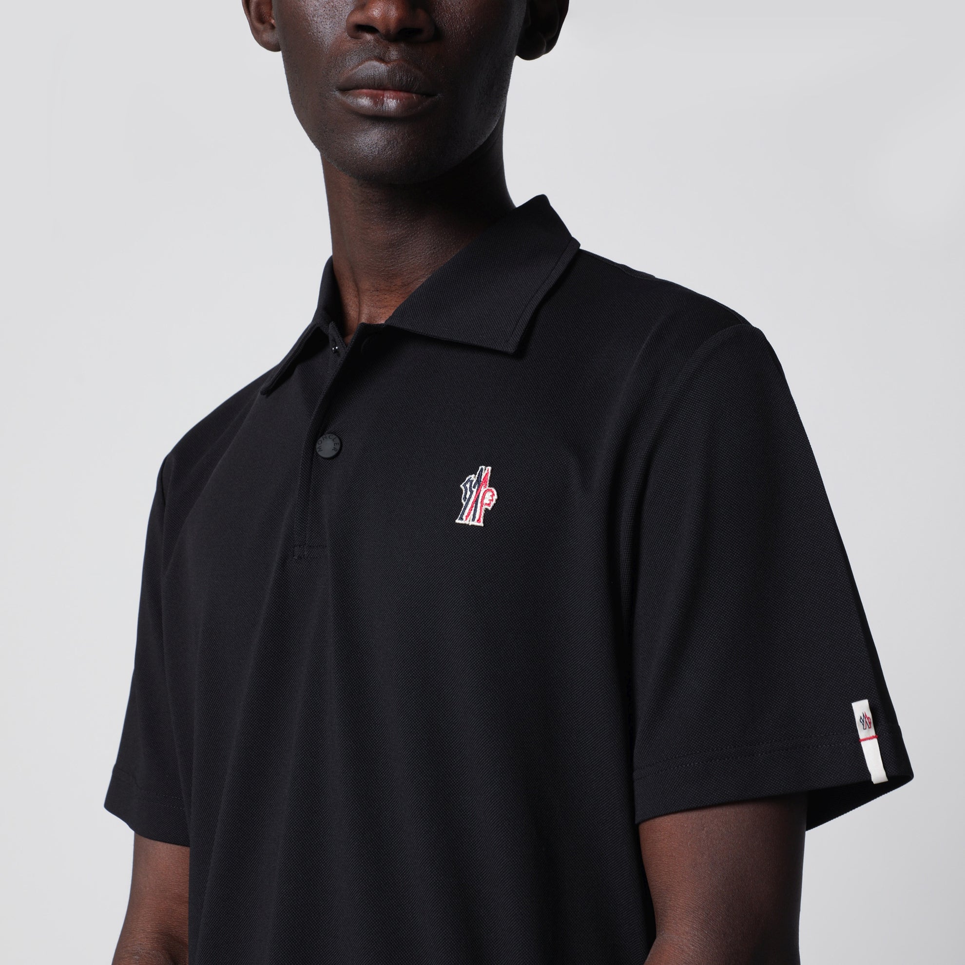 Black polo shirt with logo patch