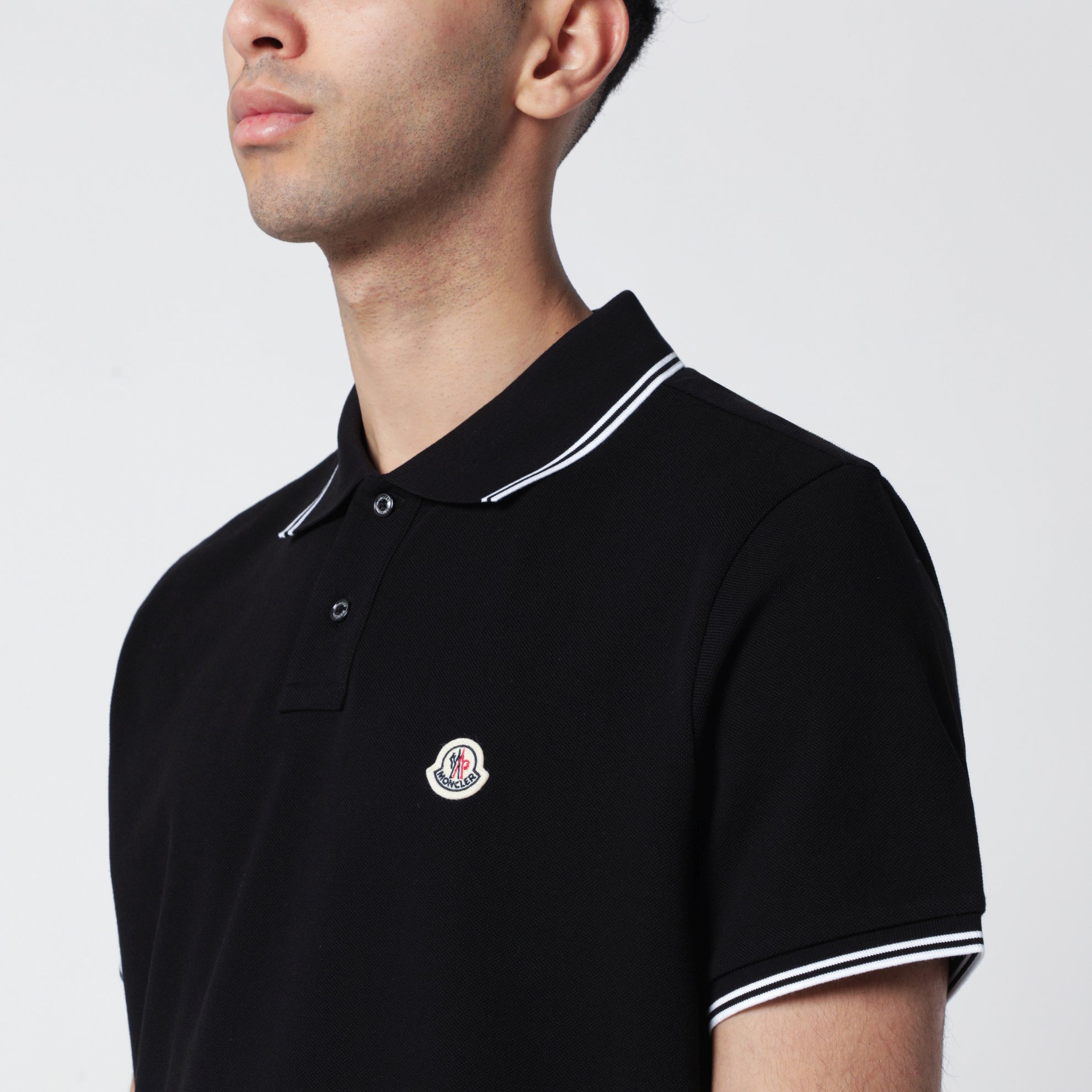 Polo nera in cotone con patch logo
