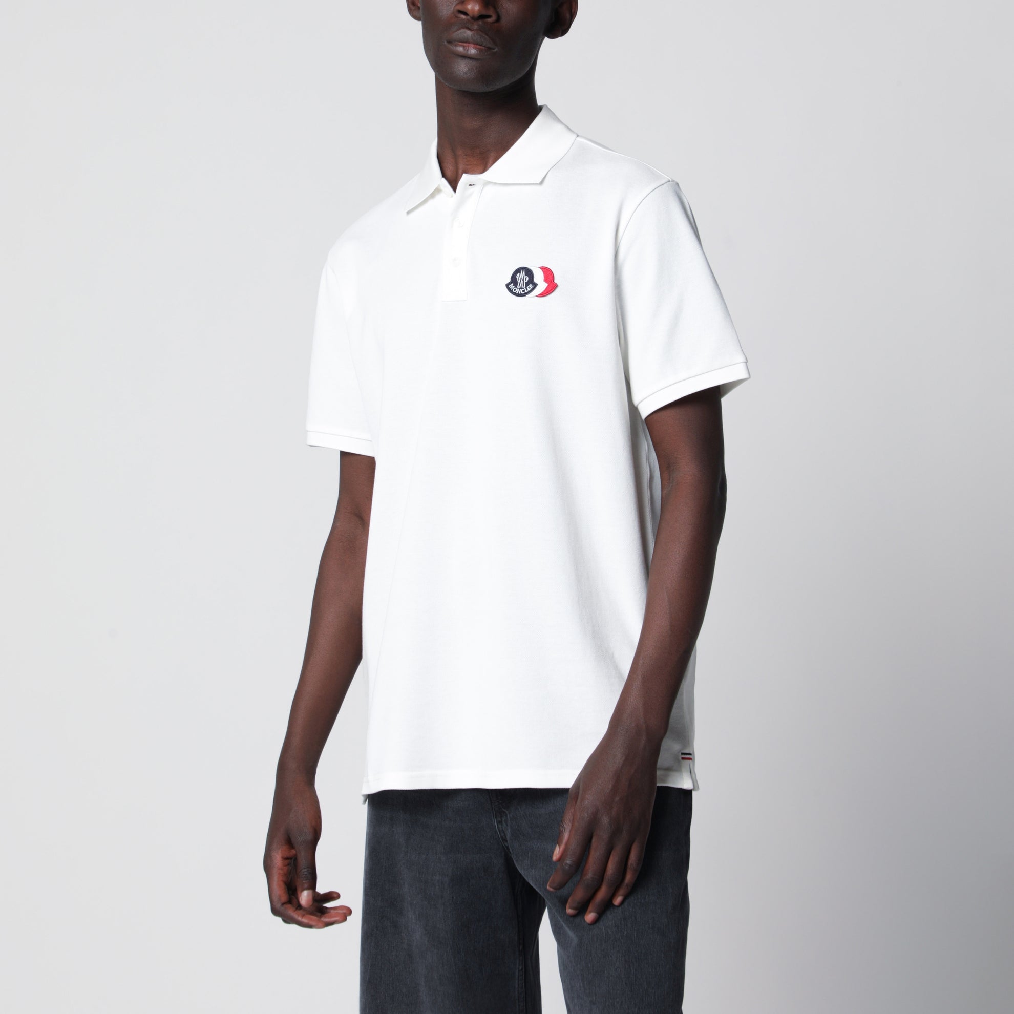 Polo bianca in cotone con patch tre stemmi logo