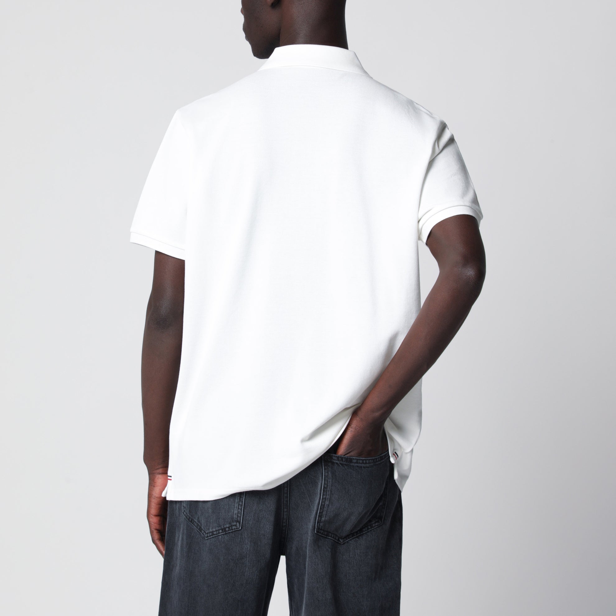 Polo bianca in cotone con patch tre stemmi logo