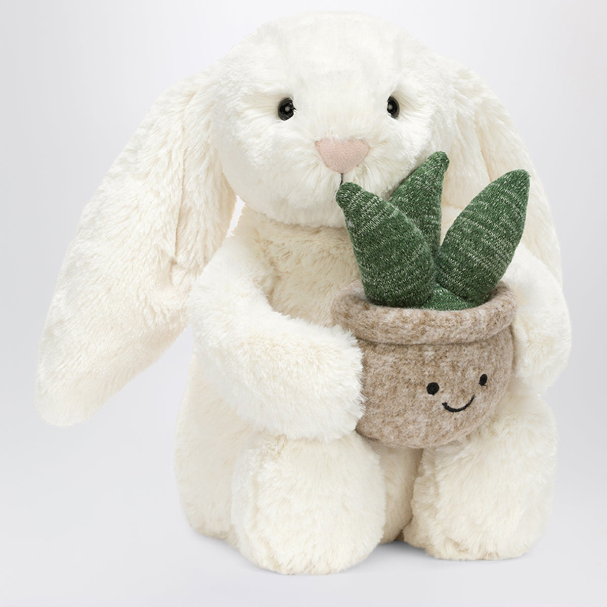 Cremefarbenes Bunny Plüschtier mit Pflanze