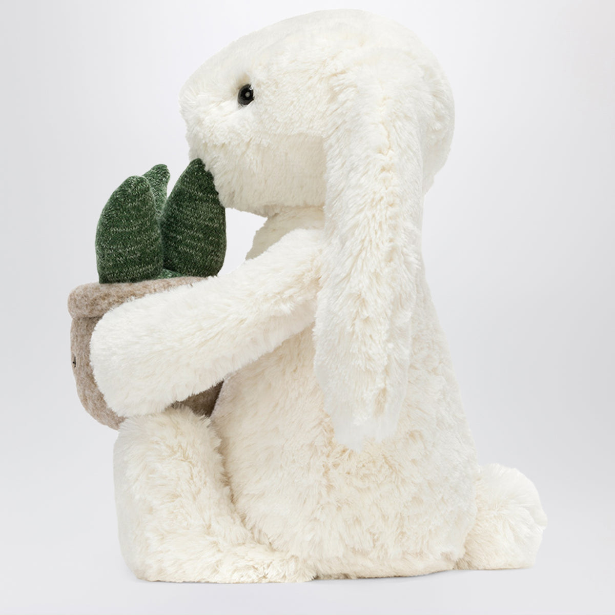Cremefarbenes Bunny Plüschtier mit Pflanze