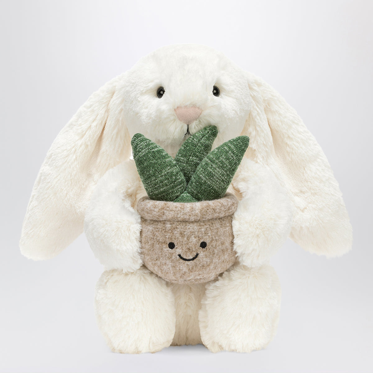 Cremefarbenes Bunny Plüschtier mit Pflanze