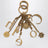Charm portachiavi Symbols Logo in ottone oro