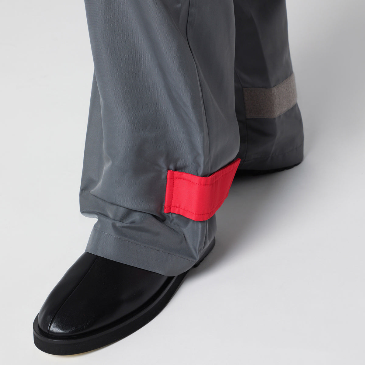 Pantaloni grigi/rossi in tessuto con finitura lucida