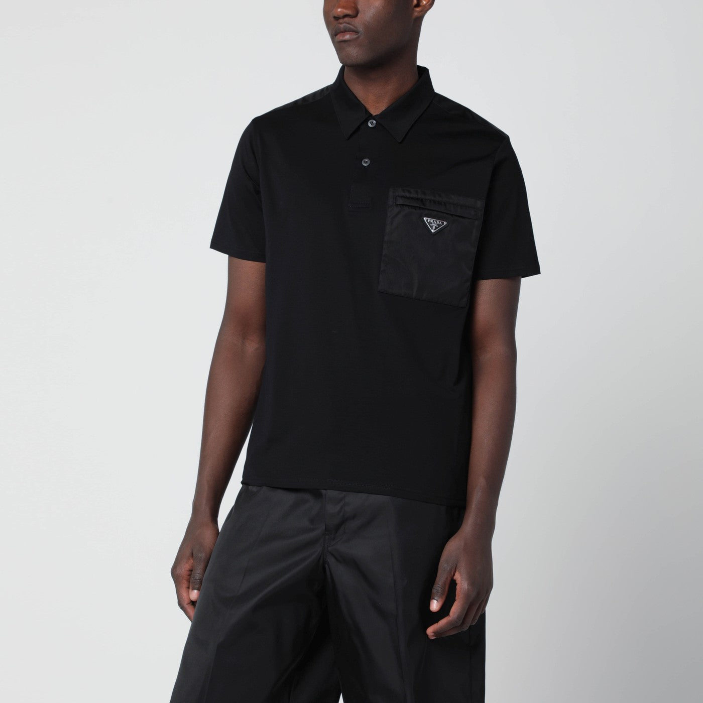 Polo nera in cotone stretch e Re-Nylon