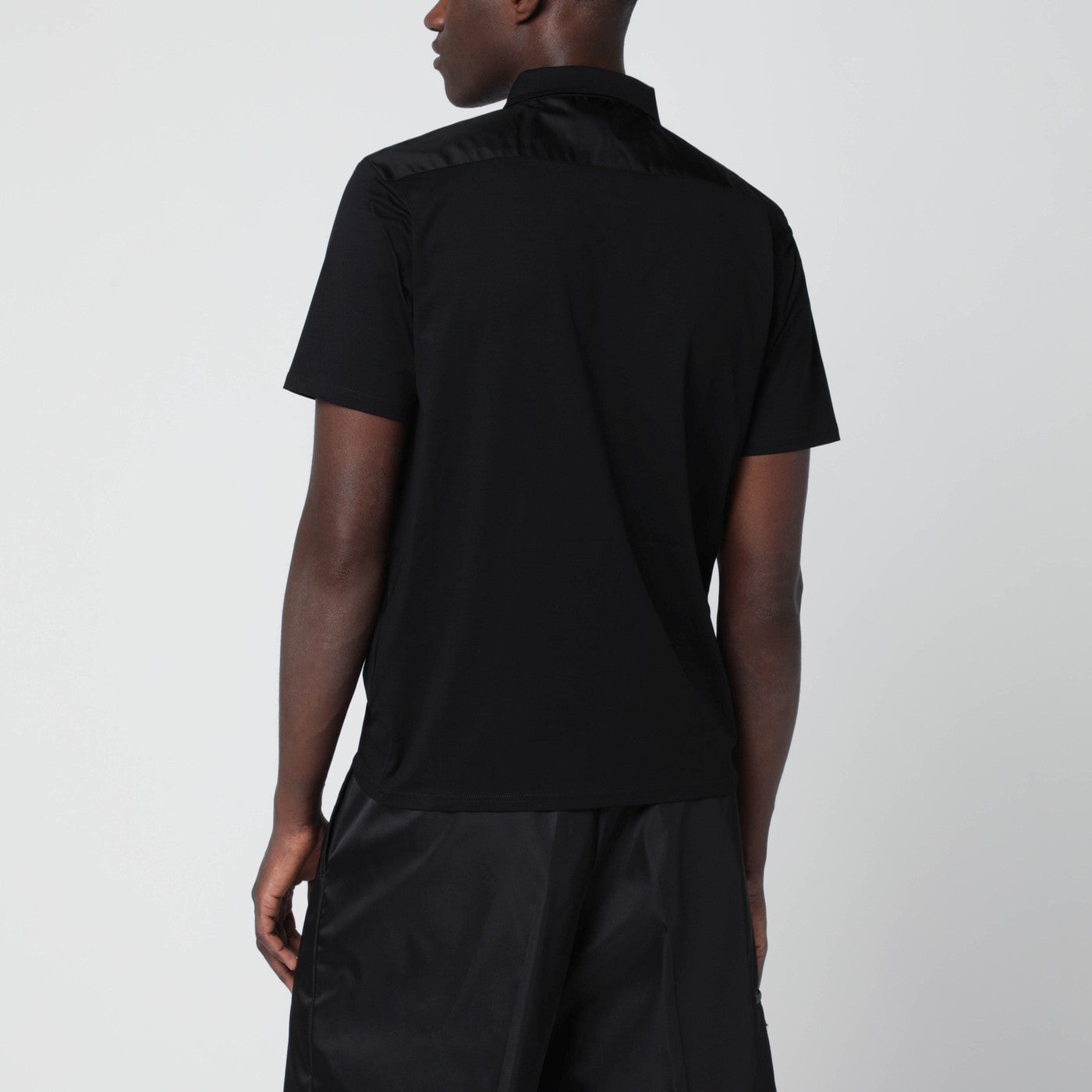 Polo nera in cotone stretch e Re-Nylon